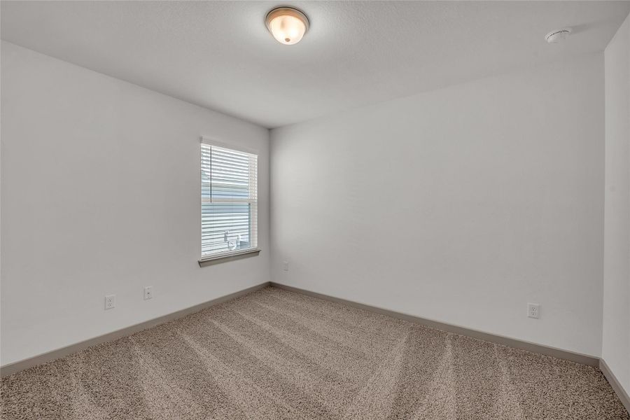 Spare room featuring carpet flooring and baseboards