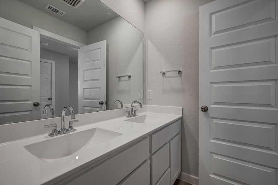 A bathroom with a large mirror.