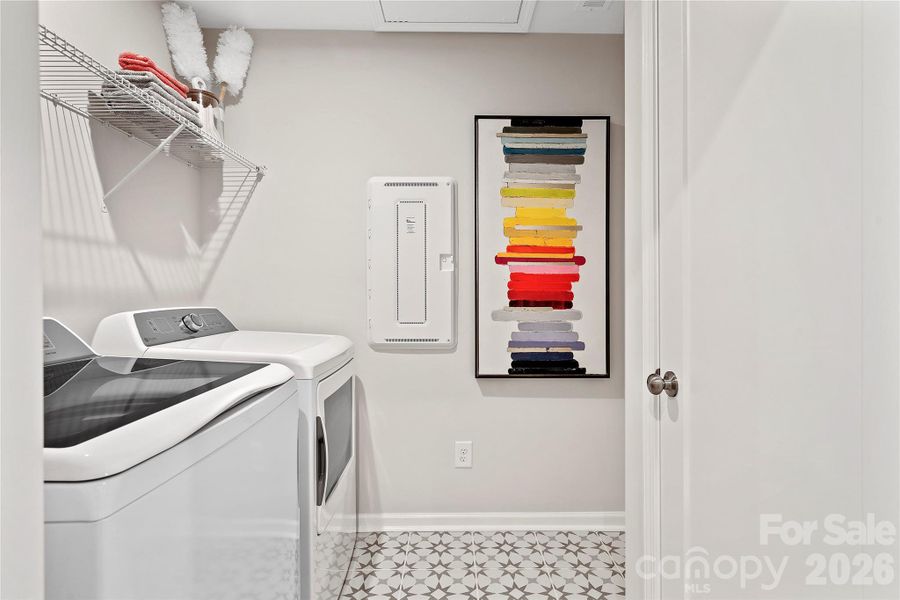 Laundry room including designer tile and washer dryer.