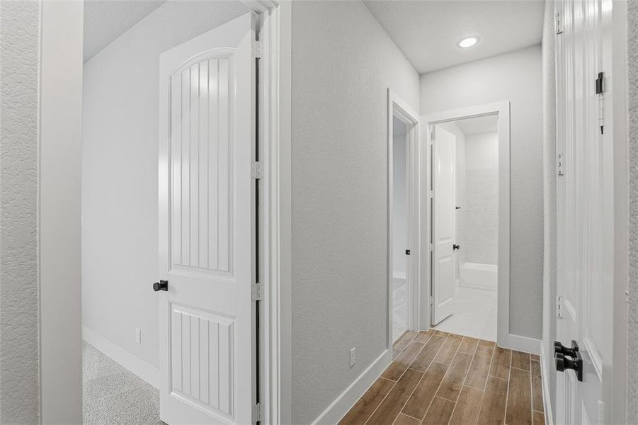 Hallway featuring wood finish floors and a textured wall