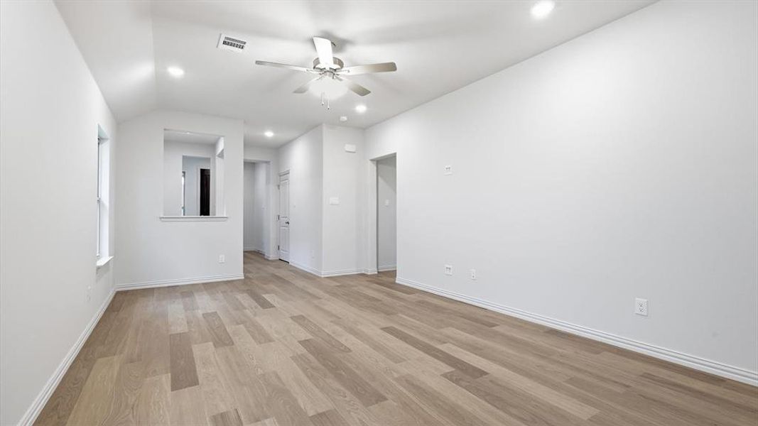 Spacious room featuring wood-finish flooring, recessed lighting, and a ceiling fan