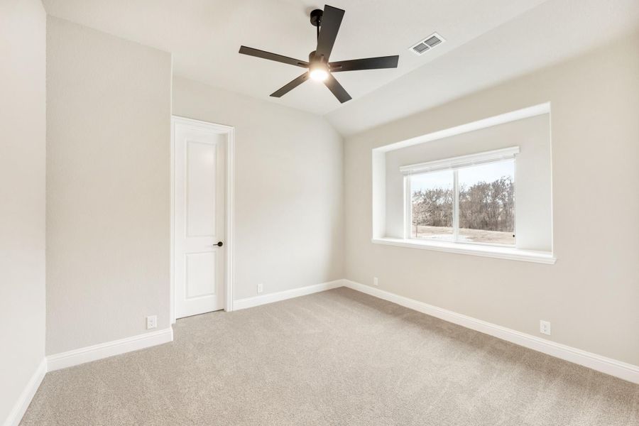 Empty bedroom with carpet flooring, black ceiling fan, and a window with outdoor views Empty bedroom with carpet flooring, black ceiling fan, and a window with outdoor views