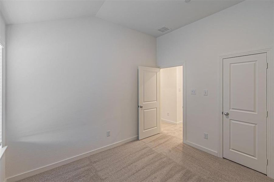 Unfurnished bedroom featuring light carpet and baseboards