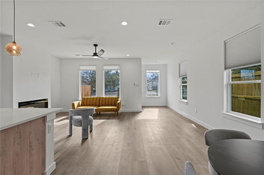 Living room with ceiling fan and light wood-type flooring