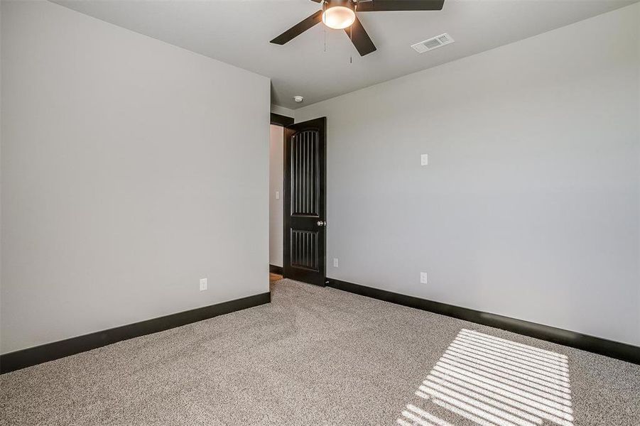 Empty room featuring ceiling fan and light colored carpet