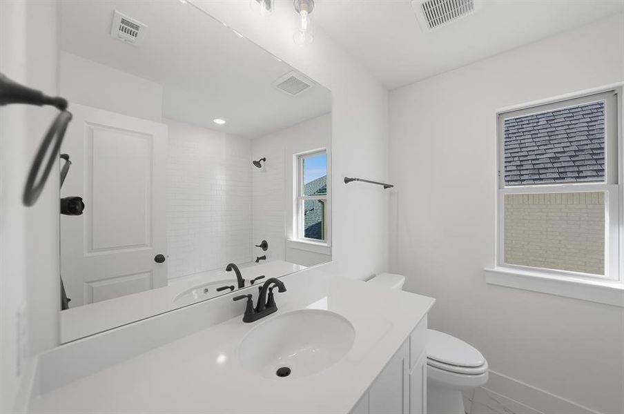 Full bath featuring vanity, marble look tiles, and bathing tub / shower combination Full bath featuring vanity, marble look tiles, and bathing tub / shower combination