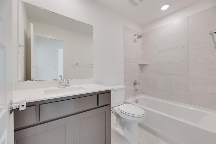 Bathroom featuring shower / bathtub combination, vanity, light tile patterned flooring, and recessed lighting Bathroom featuring shower / bathtub combination, vanity, light tile patterned flooring, and recessed lighting