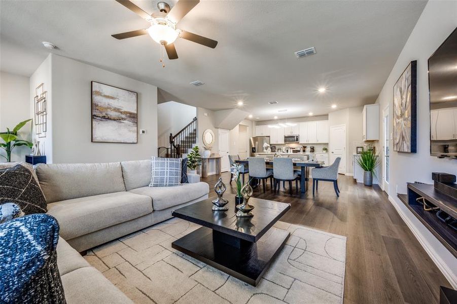 Living area with stairway, dark wood finished floors, recessed lighting, and ceiling fan Living area with stairway, dark wood finished floors, recessed lighting, and ceiling fan