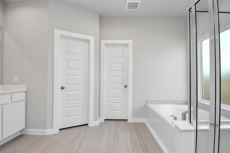 Experience a spa-like escape right in the heart of your primary bathroom.  Sample photo of completed home with similar plan. As built color and selections may vary.