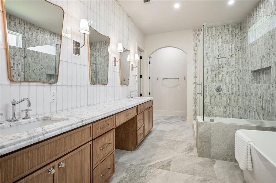 Primary bath, dual vanity, White Arabescato honed stone countertop, arched closet entry Primary bath, dual vanity, White Arabescato honed stone countertop, arched closet entry