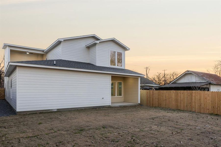 Back house at dusk featuring a patio