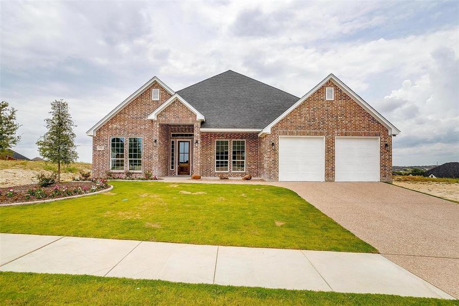 View of front of property featuring a front yard and a garage