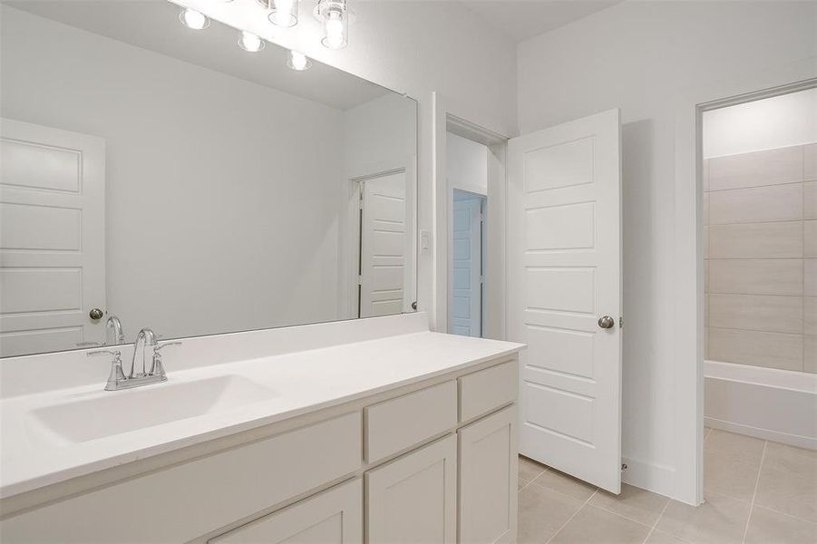 Bathroom with tile flooring, vanity, and shower / bathing tub combination