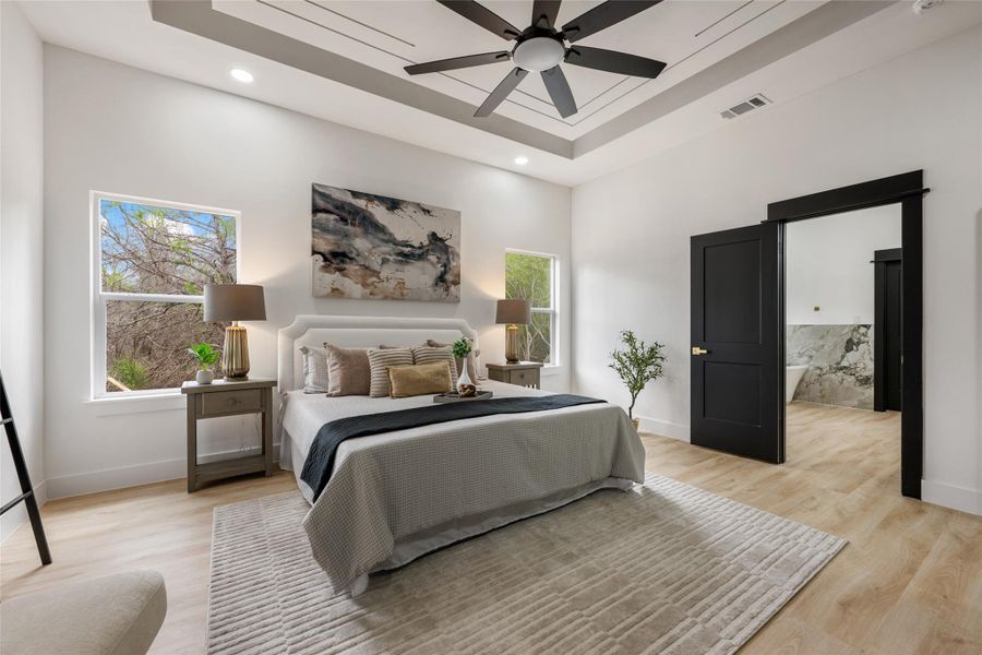Bedroom featuring a tray ceiling, a ceiling fan, light wood-style floors, and recessed lighting Bedroom featuring a tray ceiling, a ceiling fan, light wood-style floors, and recessed lighting