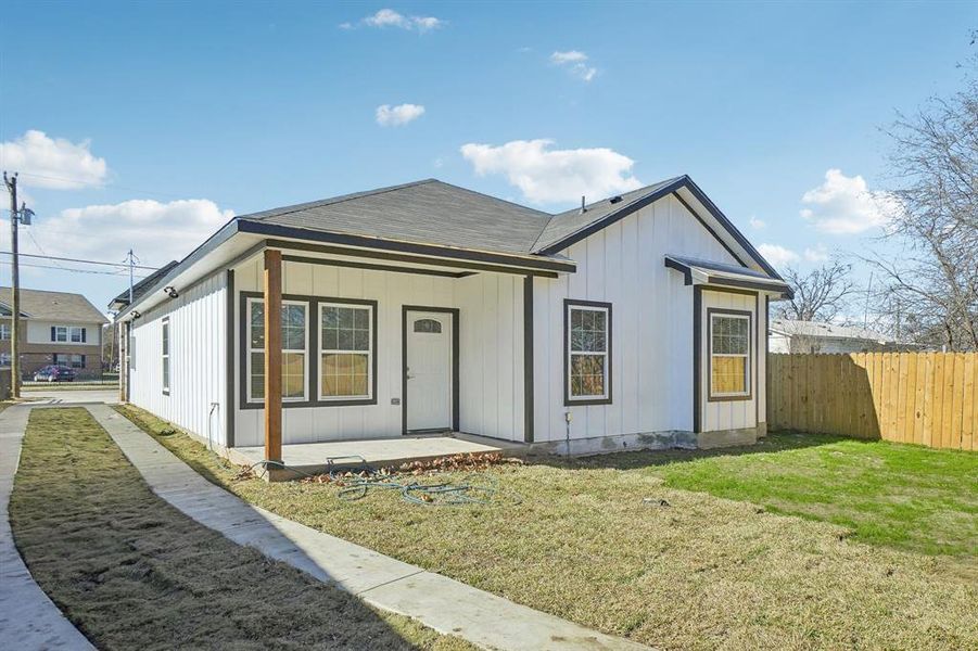 Back of house with a lawn