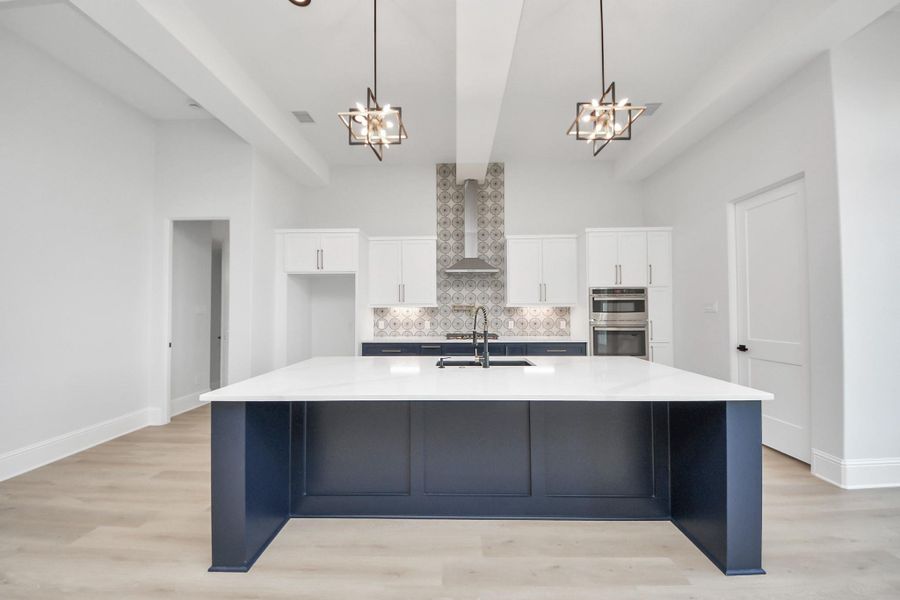 The chef’s kitchen showcases a striking oversized island, custom cabinetry, and designer lighting, opening seamlessly to the living room where expansive windows flood the space with natural light—perfect for elevated everyday living and entertaining. The chef’s kitchen showcases a striking oversized island, custom cabinetry, and designer lighting, opening seamlessly to the living room where expansive windows flood the space with natural light—perfect for elevated everyday living and entertaining.