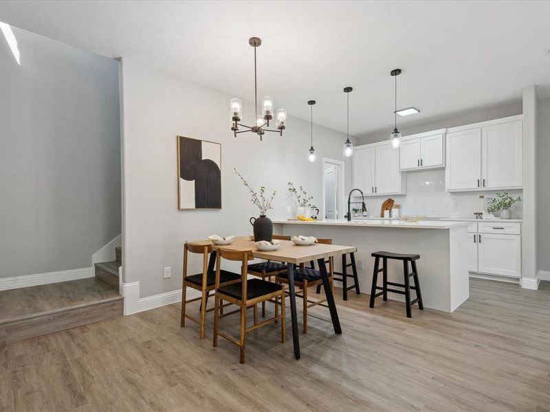 Dining room with an inviting chandelier, sink, and light hardwood / wood-style floors