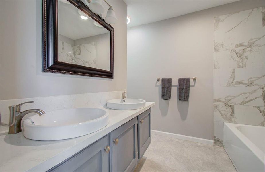 Primary bath, dual vanities, soaker tub with shower with modern backsplash surround