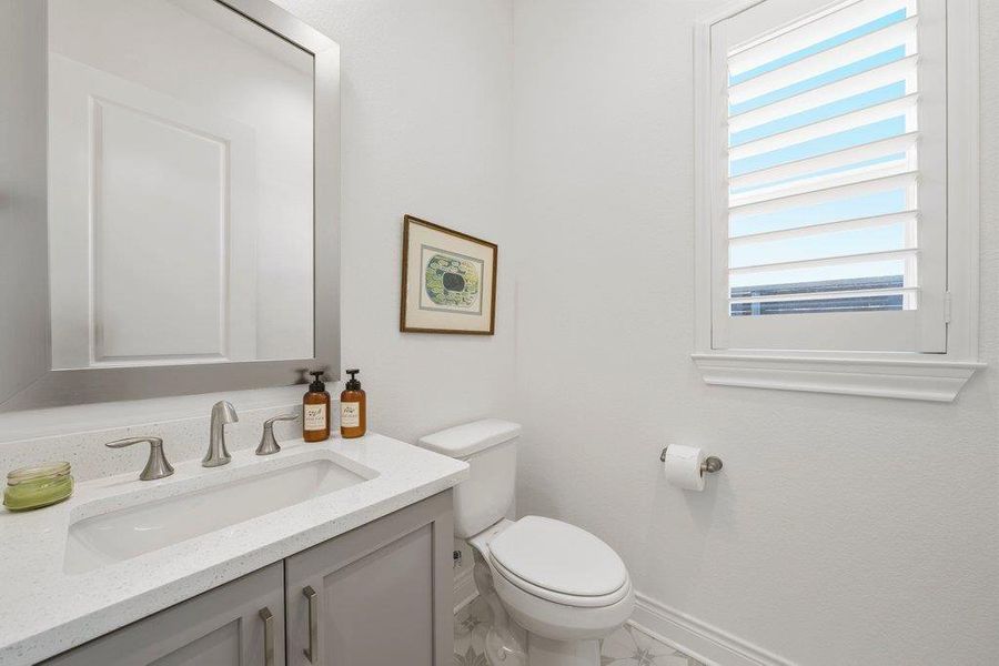 White stone counters and plantation shutters bring classic elegance to this powder room. White stone counters and plantation shutters bring classic elegance to this powder room.
