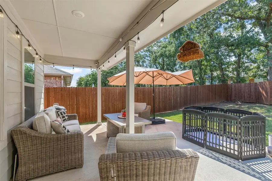 Relax and entertain on the covered back patio featuring string lights, sitting area, and extended outdoor living space. Relax and entertain on the covered back patio featuring string lights, sitting area, and extended outdoor living space.