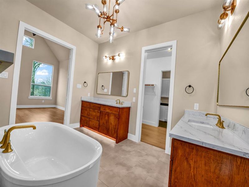 Bathroom featuring a bathtub, vanity, and a chandelier