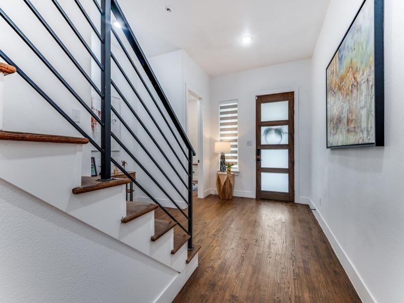 Foyer with stairs and dark wood-style floors