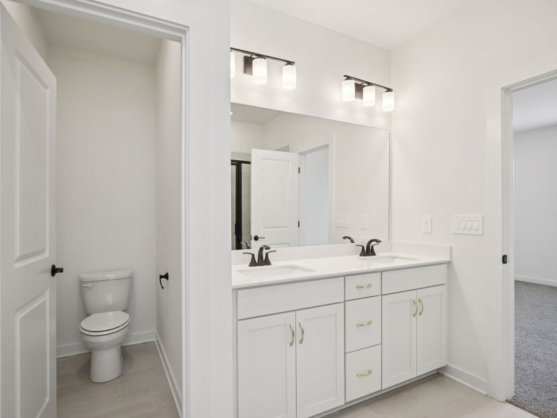 The primary bathroom offers dual vanity sinks and a walk-in shower. The primary bathroom offers dual vanity sinks and a walk-in shower.