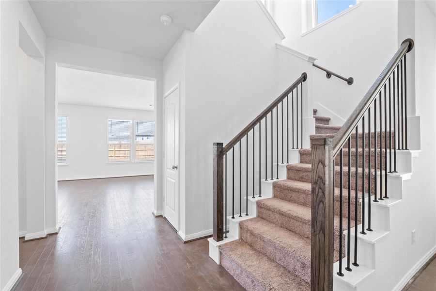 The staircase features wrought iron spindles in Dark Walnut.