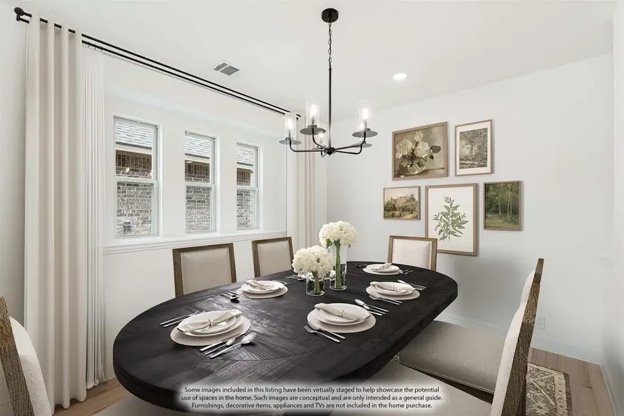 Dining room with dark oval table, six chairs, black chandelier, and gallery wall