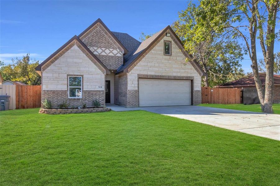 View of front of house featuring concrete driveway, brick siding, and stone siding