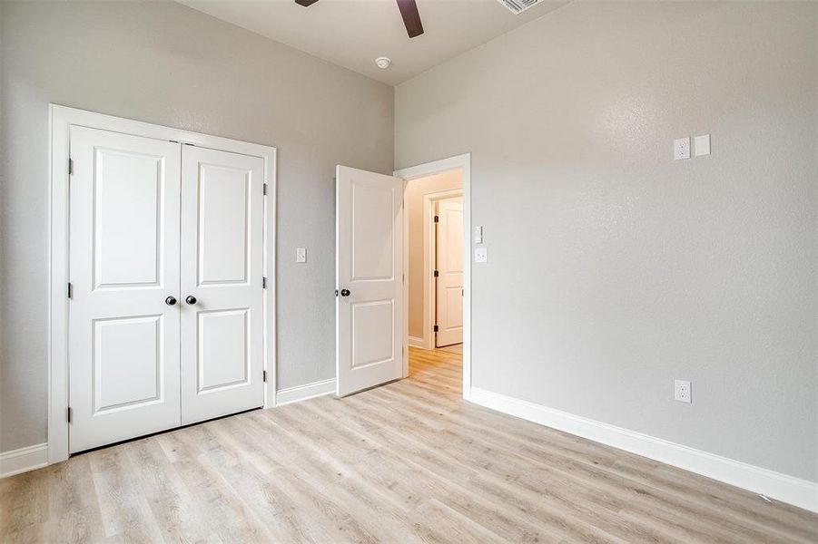 Unfurnished bedroom featuring a ceiling fan, baseboards, light wood finished floors, and a closet Unfurnished bedroom featuring a ceiling fan, baseboards, light wood finished floors, and a closet