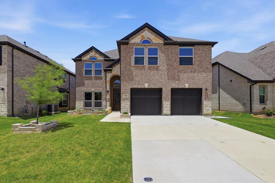 Front exterior of a new home in Valencia on The Lake, Little Elm, TX, highlighting curb appeal (Image 2). Front exterior of a new home in Valencia on The Lake, Little Elm, TX, highlighting curb appeal (Image 2).