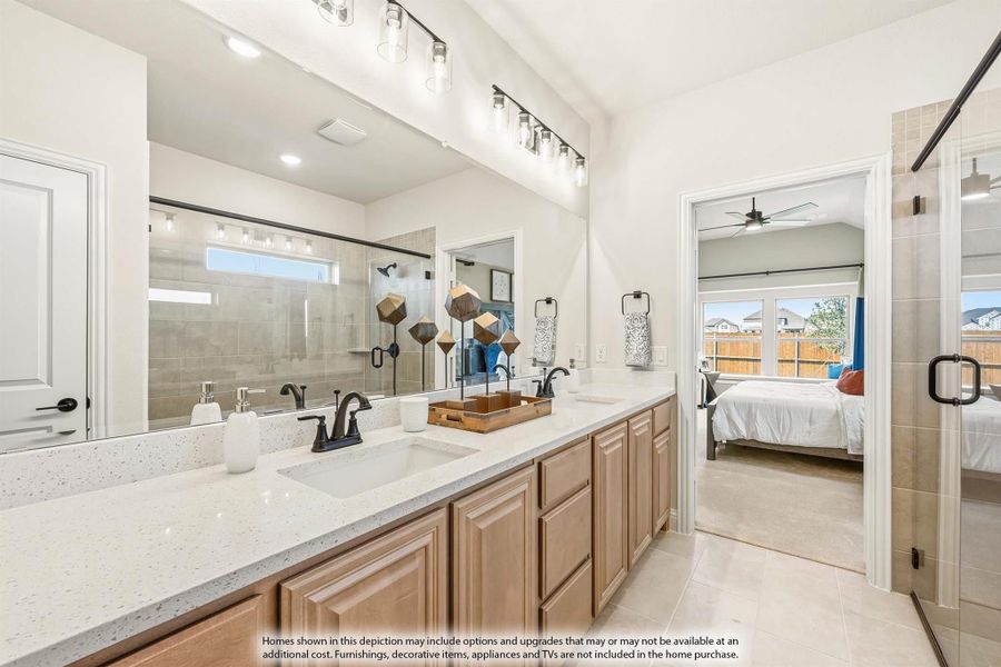 Master bathroom with double sinks, quartz countertops, wood cabinets, and tiled walk-in shower, open to bedroom