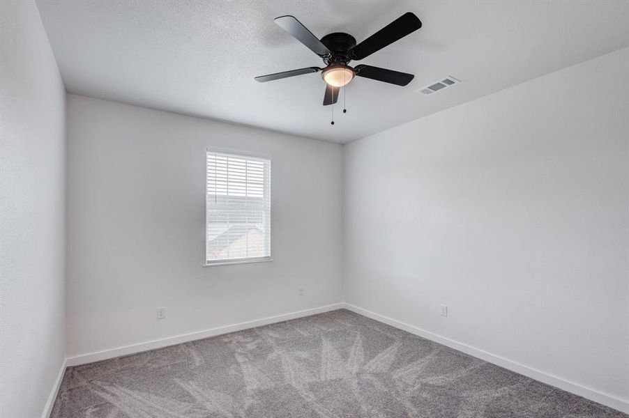 Carpeted spare room with ceiling fan