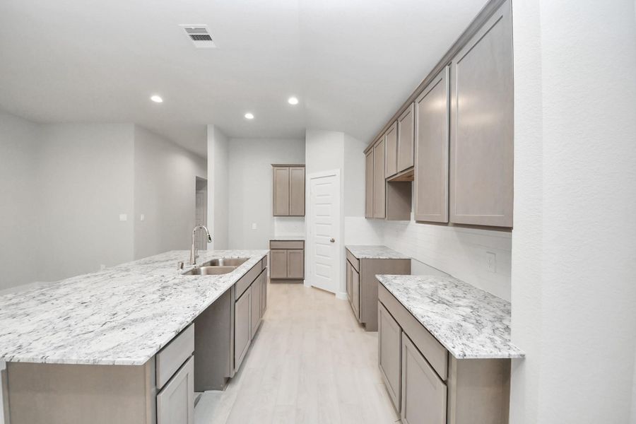 The open concept effortlessly connects the kitchen to the expansive family room, forming a perfect hub for gatherings. This seamless flow creates an inviting space where cooking and socializing come together harmoniously. Sample photo of completed home with similar floor plan. Actual colors and selections may vary.