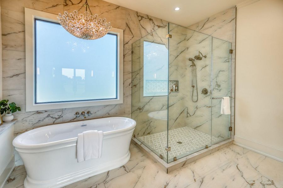 Full bathroom featuring marble tiled flooring, a soaking tub, healthy amount of natural light, a marble finish shower, and recessed lighting Full bathroom featuring marble tiled flooring, a soaking tub, healthy amount of natural light, a marble finish shower, and recessed lighting