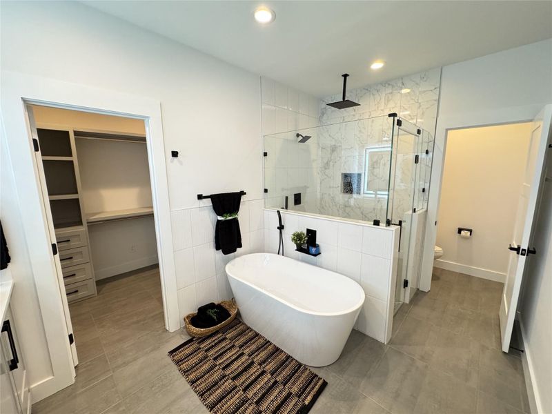 Bathroom featuring a stall shower, a soaking tub, a walk in closet, recessed lighting, and tile patterned flooring Bathroom featuring a stall shower, a soaking tub, a walk in closet, recessed lighting, and tile patterned flooring