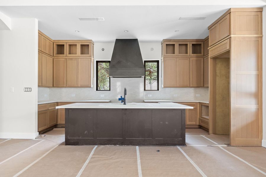 Central kitchen island with a dark-toned finish and white countertop