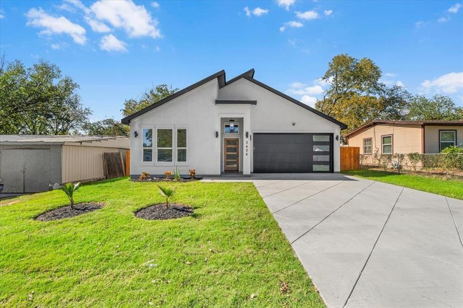 Modern home with stucco siding, concrete driveway, and a garage