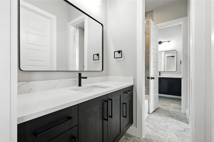 Full bath with vanity, marble finish flooring, and a tub to relax in