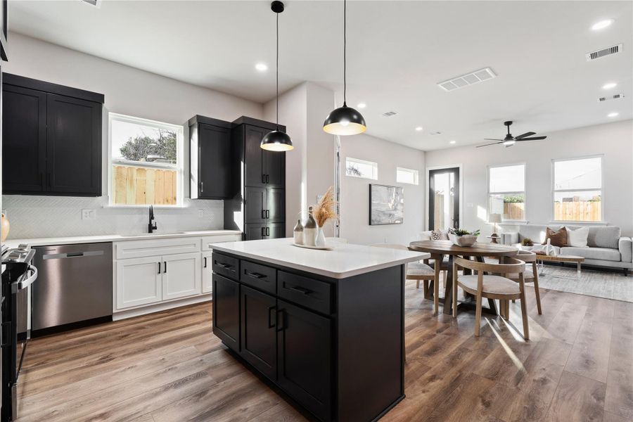 This stunning open-concept main level is designed for effortless living, with a spacious kitchen that flows seamlessly into the dining and living areas. Natural light pours in through oversized windows, creating a bright, welcoming atmosphere perfect for gathering and entertaining.