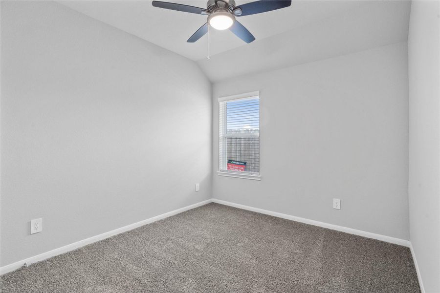 This cozy secondary bedroom offers plush soft carpeting, neutral walls ready for personalization, a sun-filled window with fitted blinds, sloped ceilings, and a spacious closet for all your storage needs.