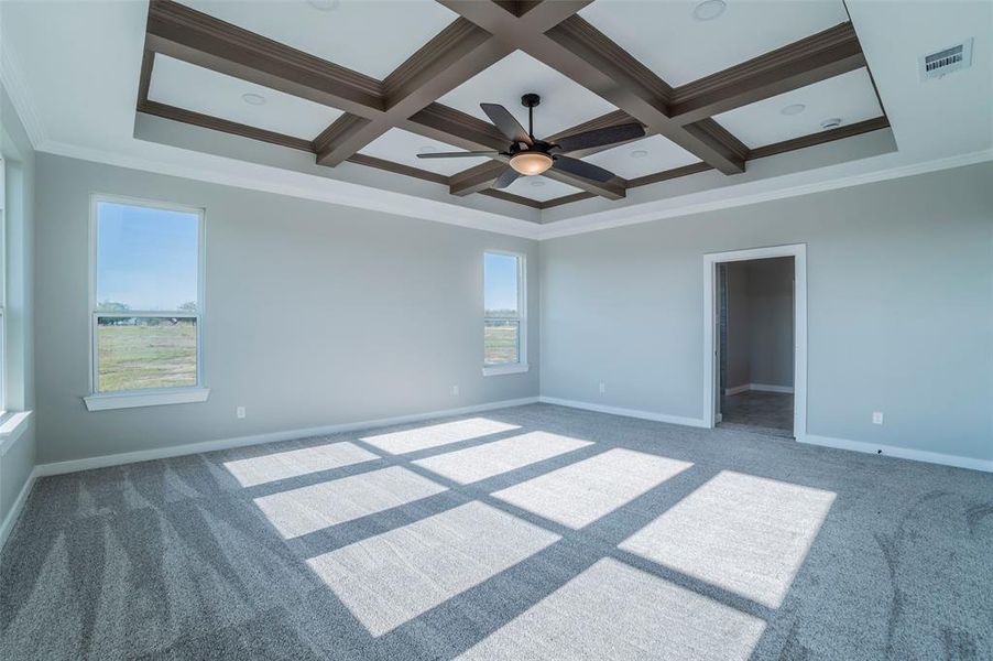 Carpeted spare room featuring ornamental molding, coffered ceiling, a ceiling fan, and beam ceiling Carpeted spare room featuring ornamental molding, coffered ceiling, a ceiling fan, and beam ceiling