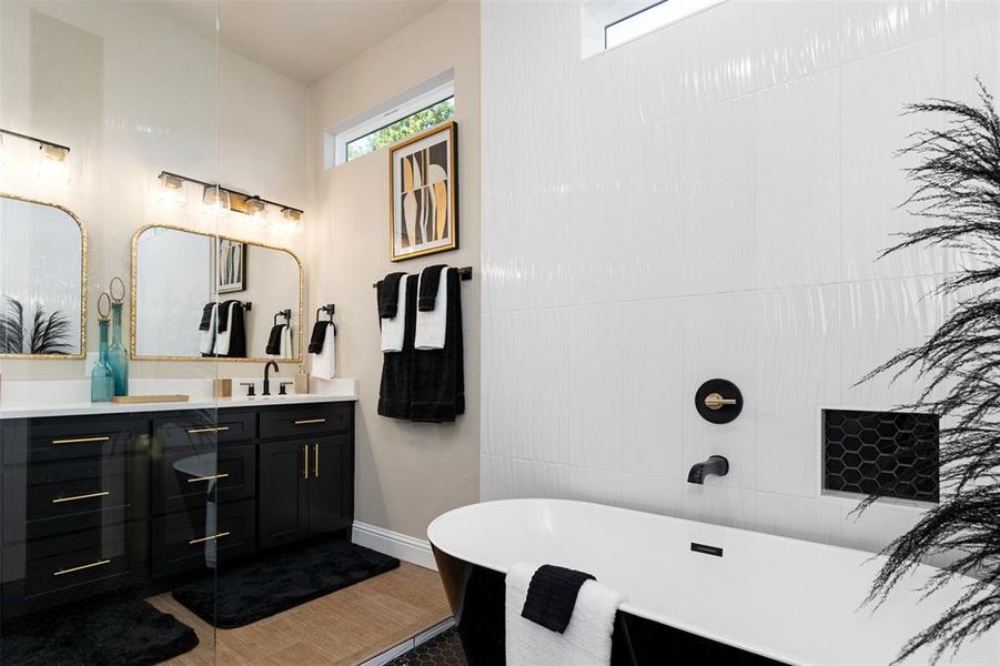 Bathroom with hardwood / wood-style floors, a tub to relax in, and vanity