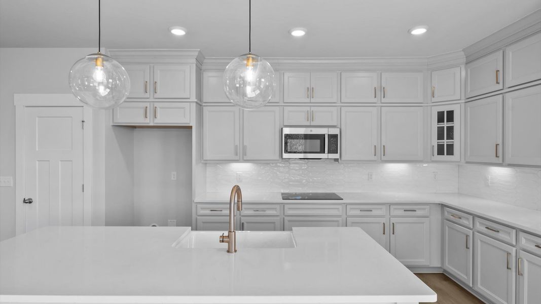 Highly skilled craftsmanship shines in this modern, gourmet kitchen with pendant lighting and a central island focal point