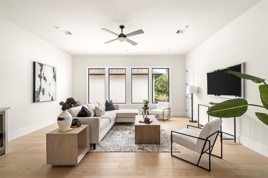 Spacious upstairs living area offering a versatile retreat for relaxation or entertainment. Filled with natural light from large picture windows and anchored by sleek wood flooring, this space combines comfort with modern design. Spacious upstairs living area offering a versatile retreat for relaxation or entertainment. Filled with natural light from large picture windows and anchored by sleek wood flooring, this space combines comfort with modern design.