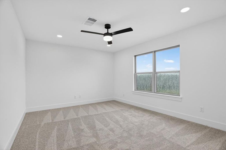 Spacious room featuring neutral carpeting, recessed lighting, and a modern ceiling fan with integrated lighting