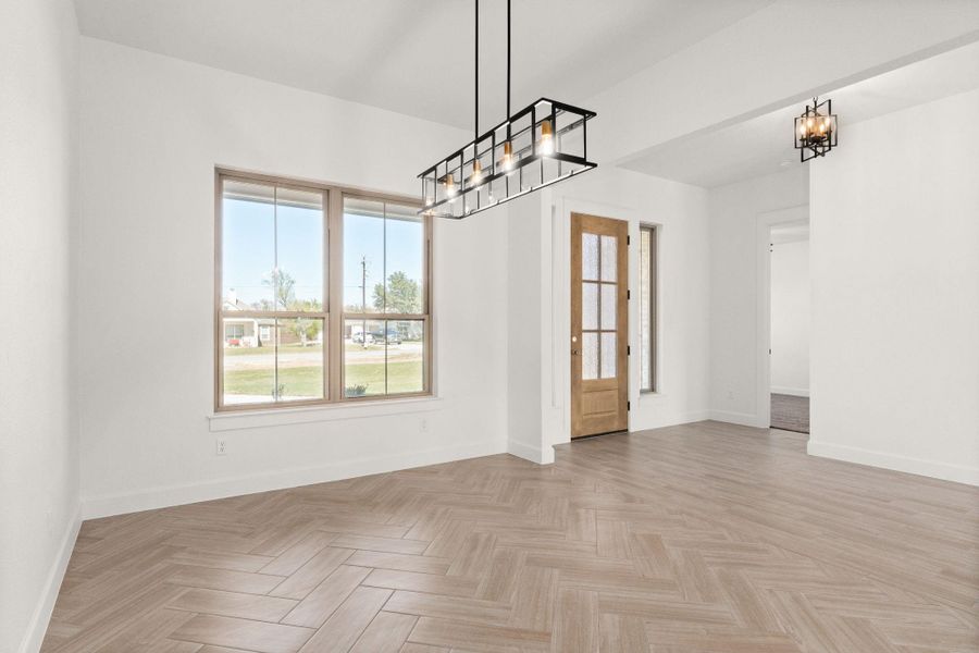 Empty room with a chandelier and baseboards