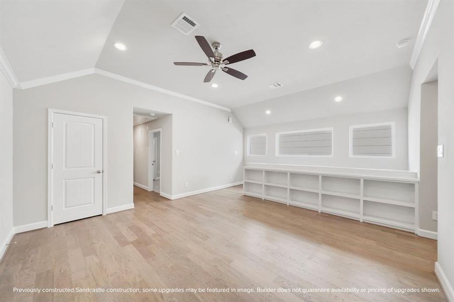 Sitting at the top of the stairs, this game room is filled with natural light and features built-in shelves, a dedicated closet, and a ceiling fan.