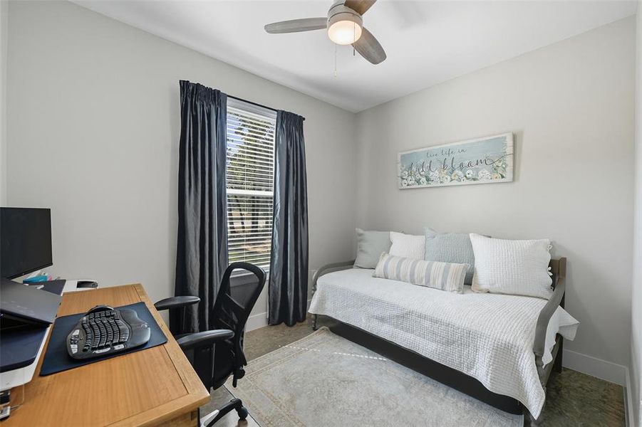 Carpeted bedroom featuring a ceiling fan and a desk Carpeted bedroom featuring a ceiling fan and a desk